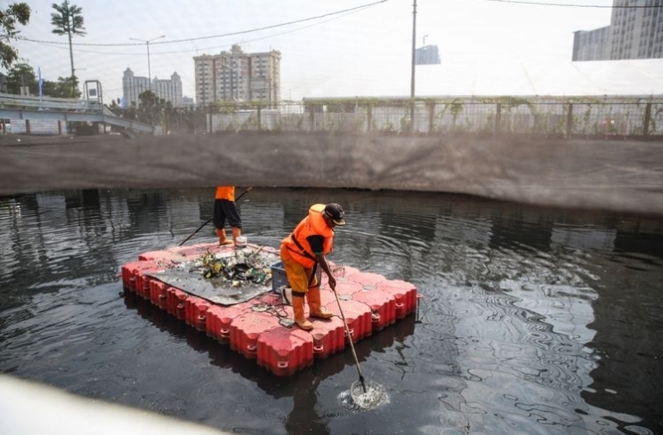 Pekerja membersihkan sampah di Kali Item, Jakarta Utara