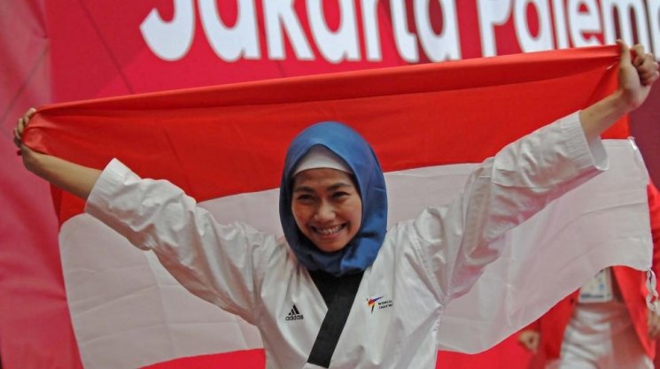 Defia Rosmaniar, sumbang medali emas pertama untuk Indonesia di cabang olahraga taekwondo. (ANTARA FOTO/INASGOC/Sunyoto)