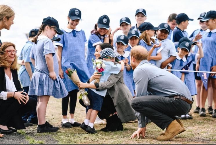 Meghan Markle sedang memeluk seorang anak laki-laki yang memberinya bunga. (twitter)